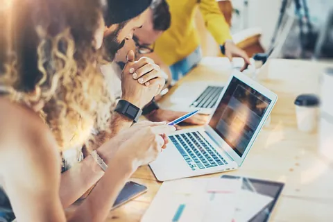 jovenes trabajando en mesa de reuniones